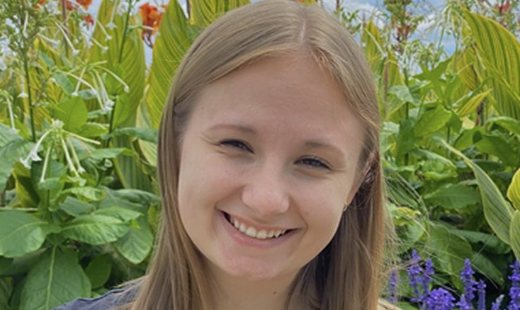 A woman with blond hair looks at the camera